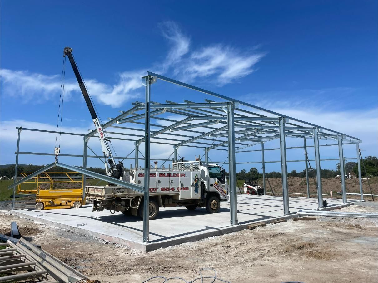 Steel Frame of a Building Under Construction With a Truck and Crane on Site — Bridgey's Constructions in Bulahdelah, NSW