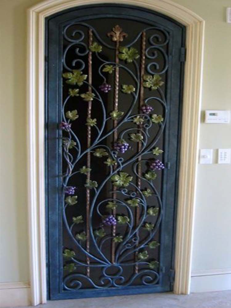 A wrought iron door with grapes and leaves on it