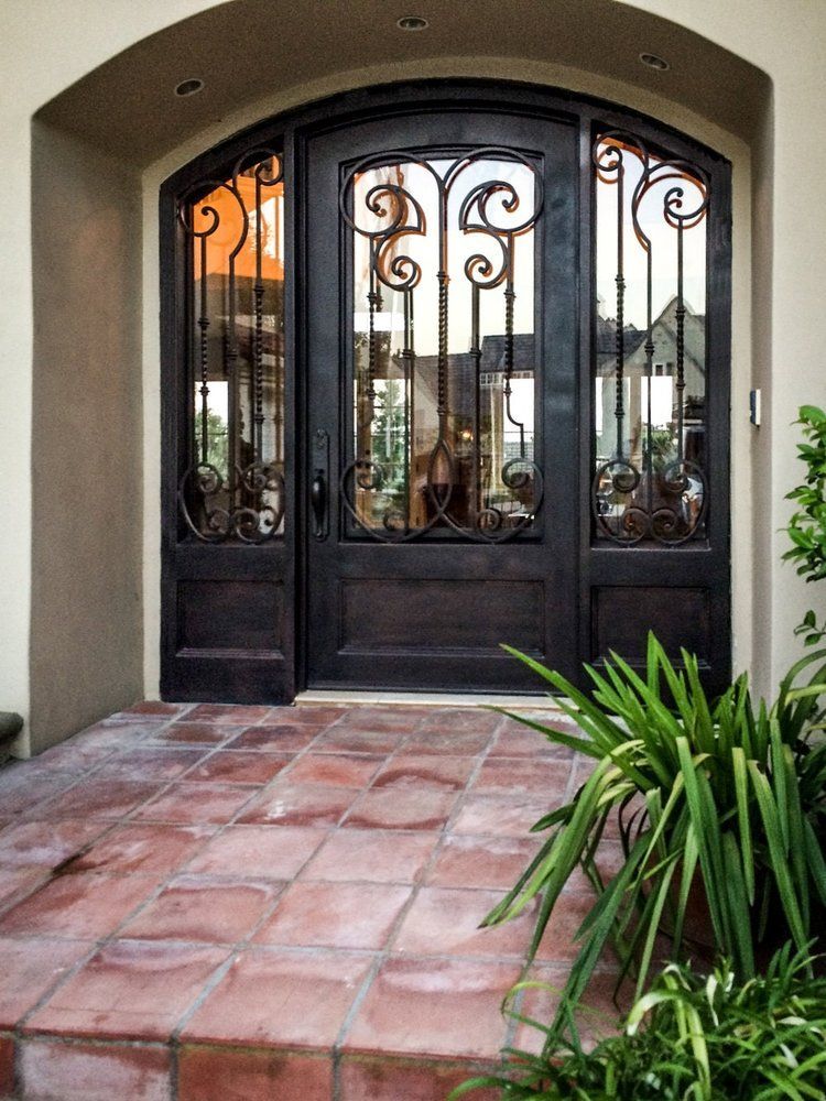 The front door of a house has a wrought iron design on it.