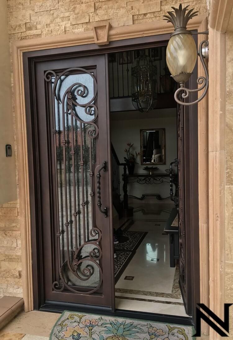 A wrought iron door is open to a living room.