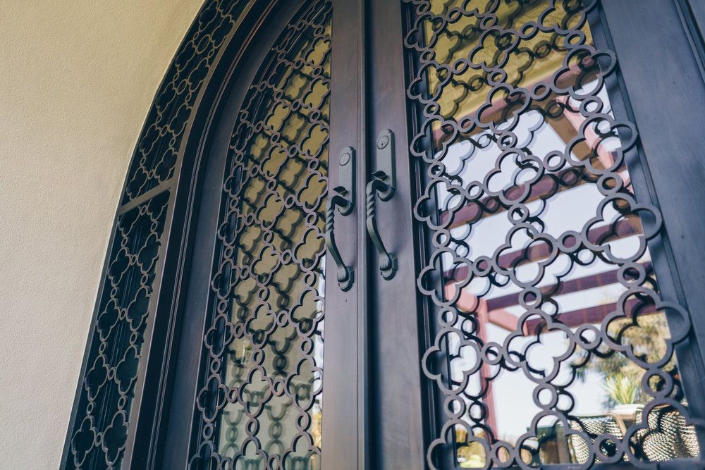 A close up of a wrought iron door with a pattern on it