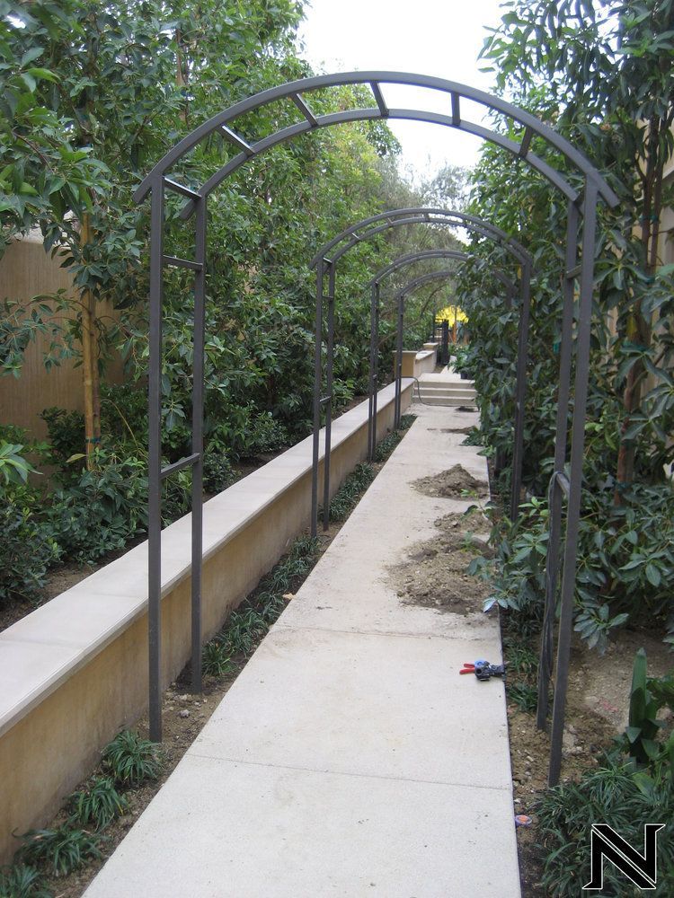 A walkway with a metal arch and the letter n on the bottom