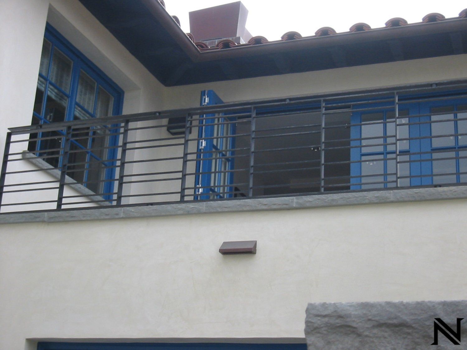 A white building with a balcony and a sign that says n