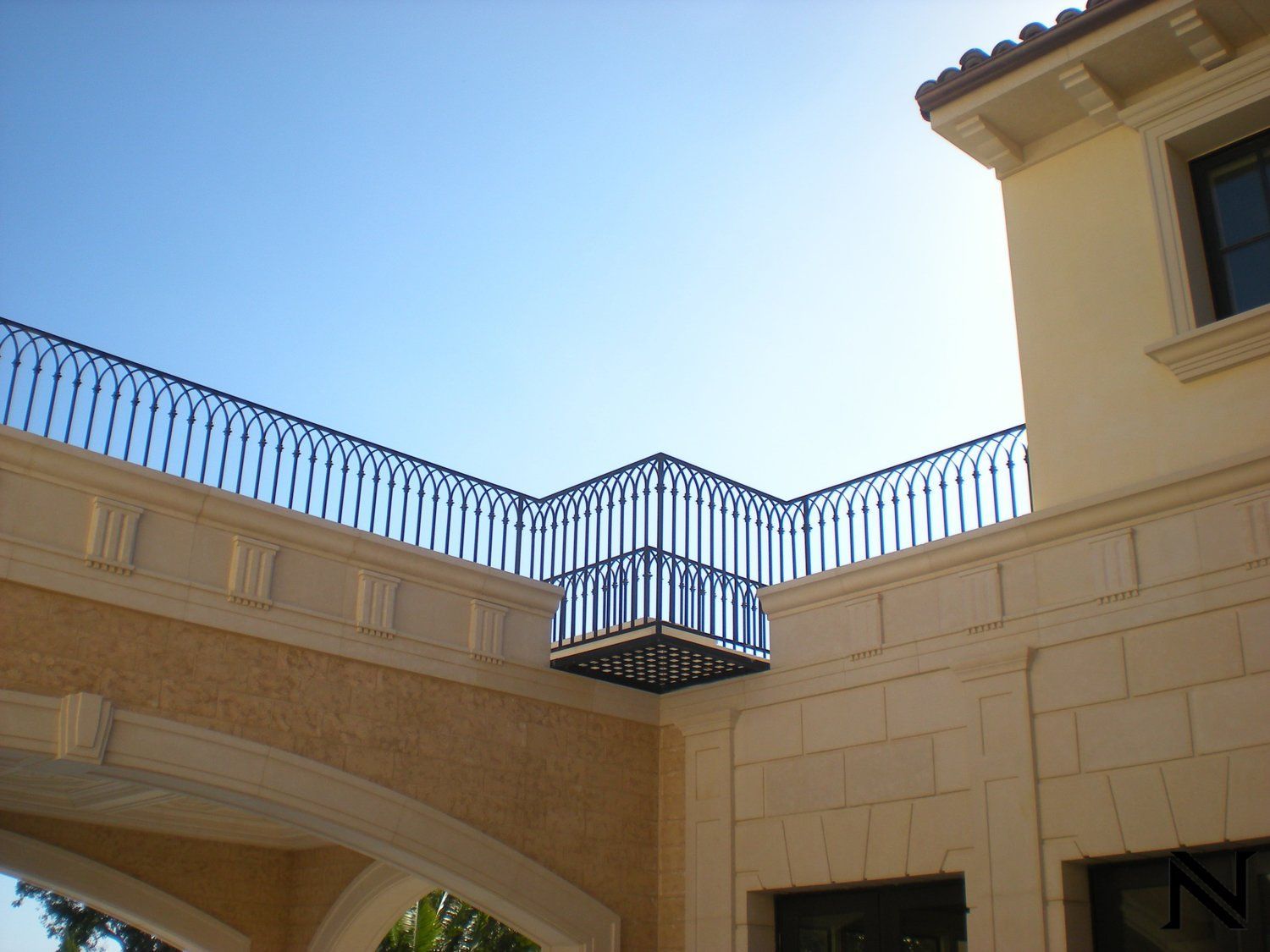 A balcony on the side of a building with a blue sky in the background