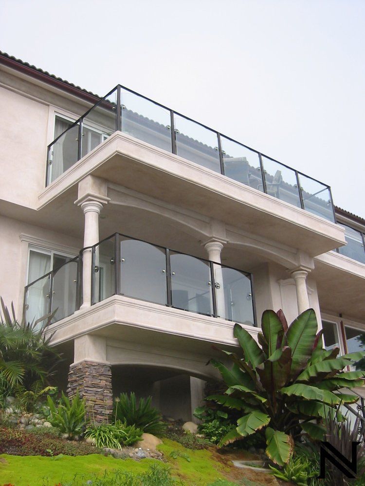 A large house with a balcony with glass railing