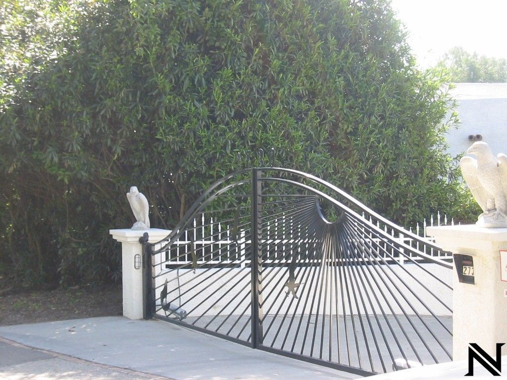 A wrought iron gate with a statue of an eagle on top of it