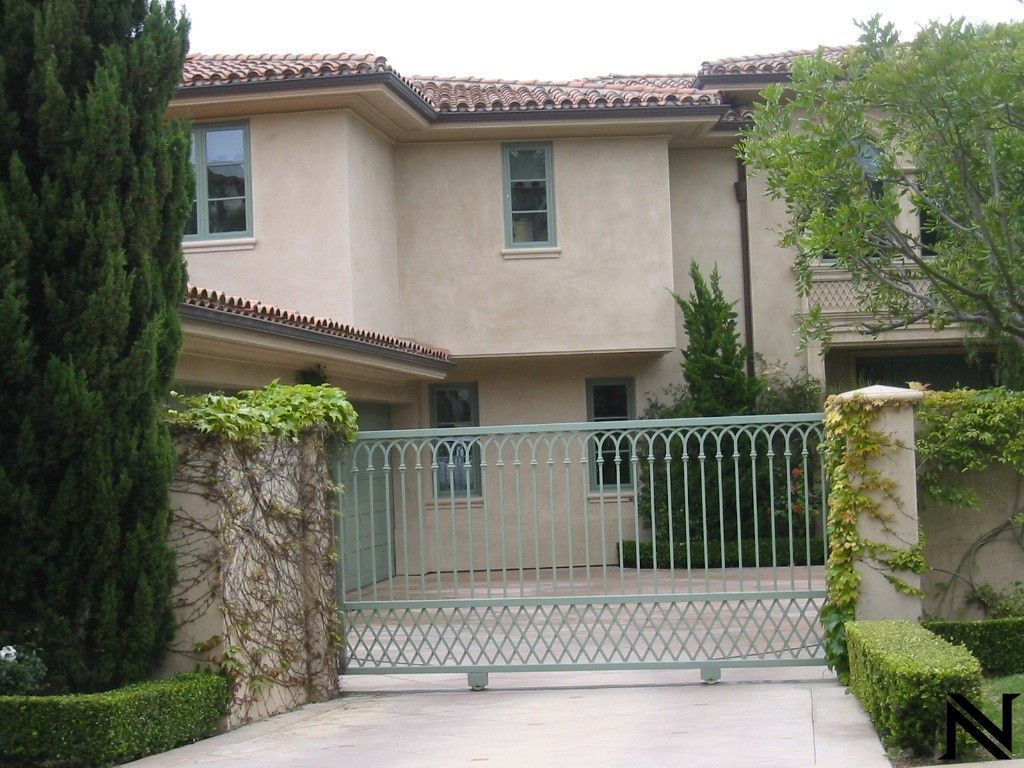 A large house with a green gate in front of it