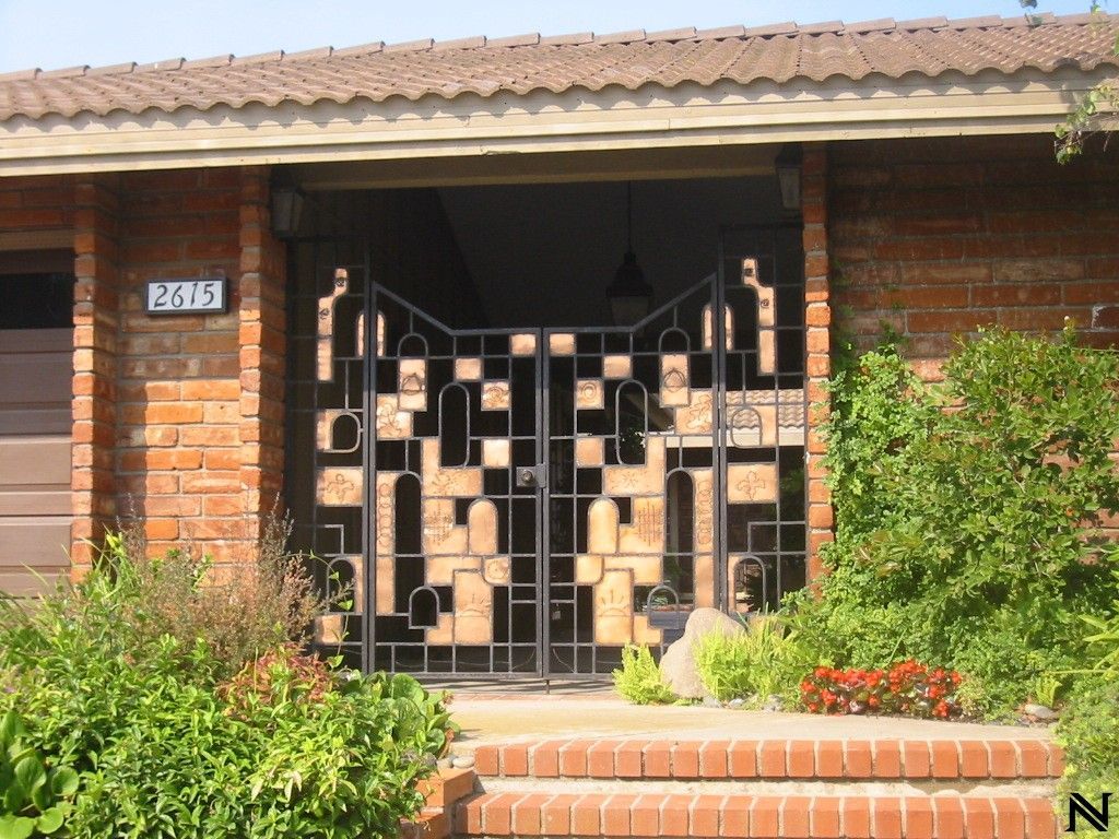 A brick house with a gate that says 2105 on it