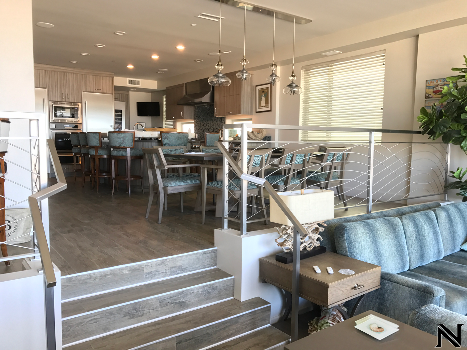 A living room with a couch and stairs leading to a kitchen and dining room.