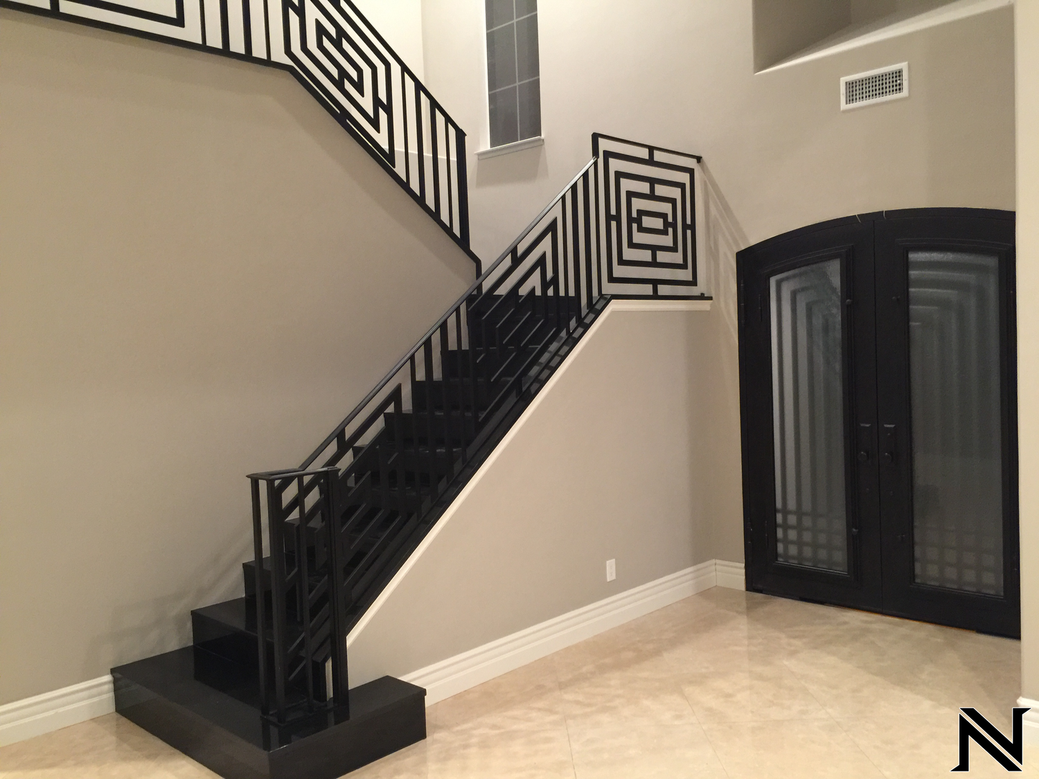 An empty room with a staircase and a door with the letter n on it