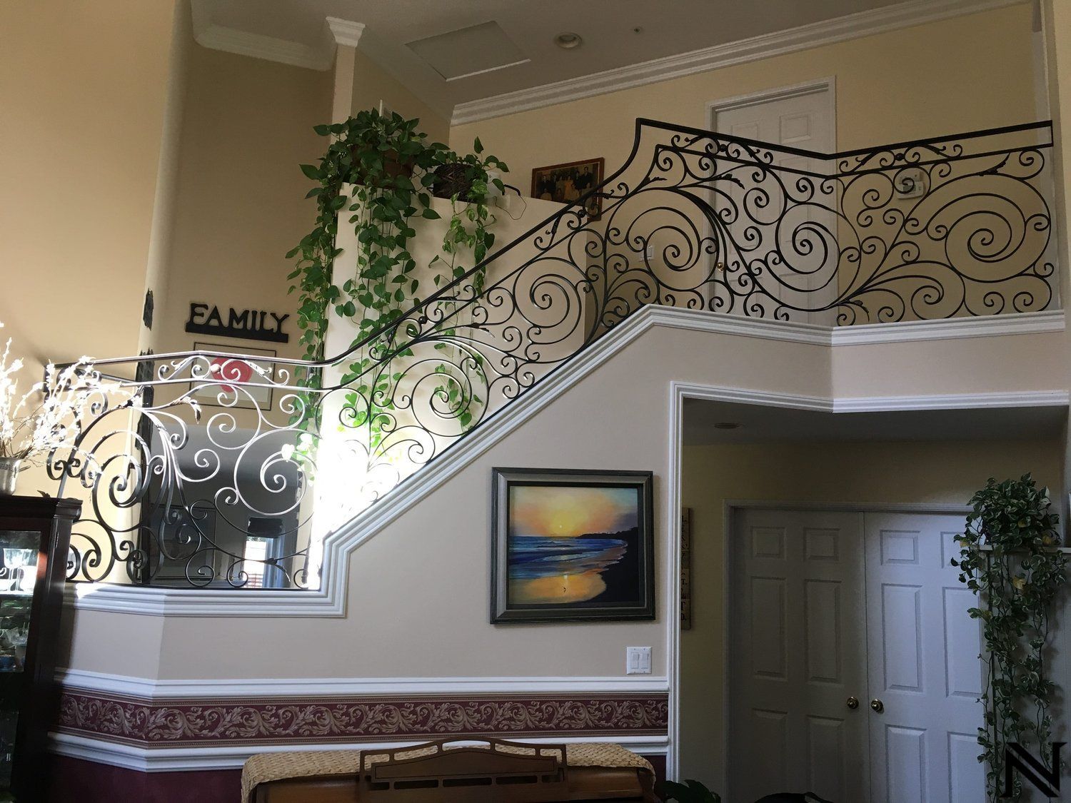A staircase with a wrought iron railing and a sign that says family