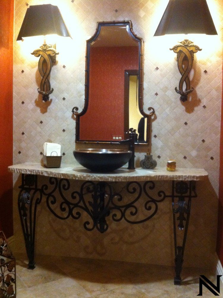 A bathroom with a sink and a mirror with the letter n on the bottom