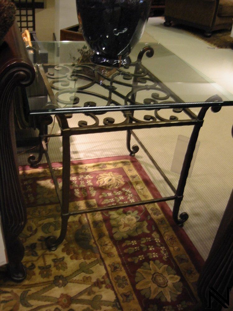 A glass table with a vase on top of it