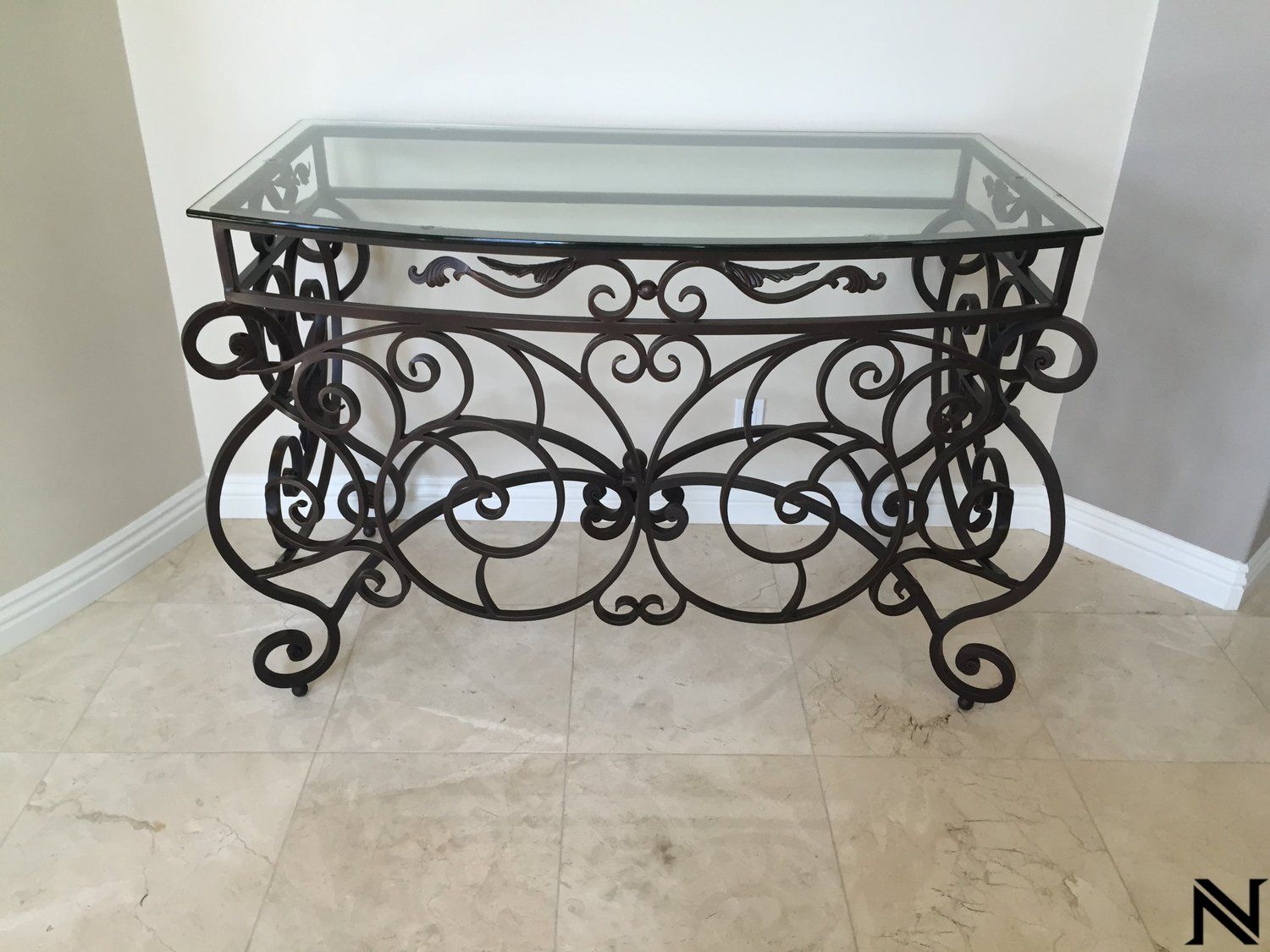 A wrought iron table with a glass top