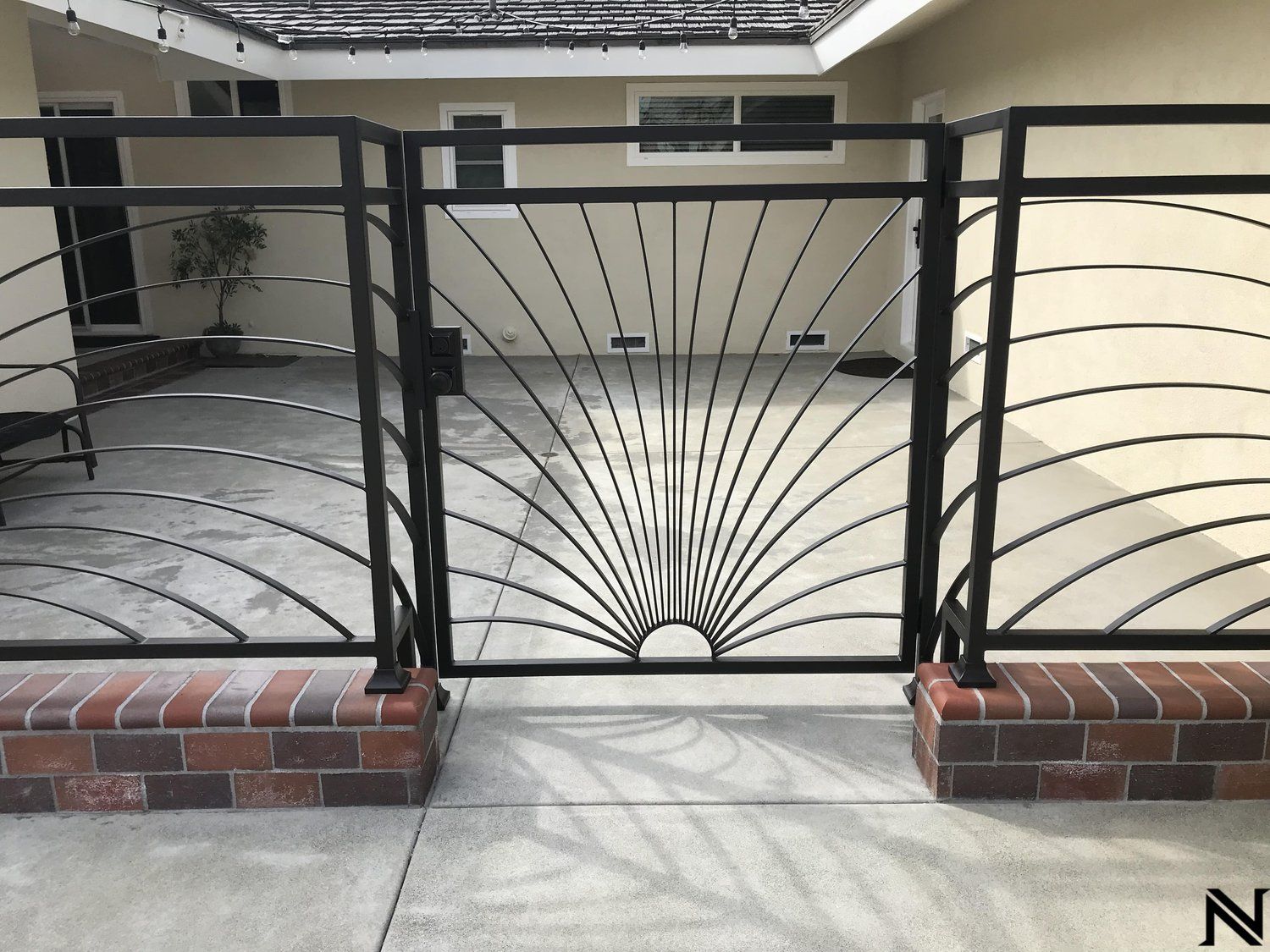A wrought iron gate with a sun design on it