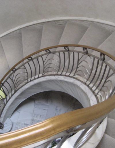 A close up of a spiral staircase with a gold railing