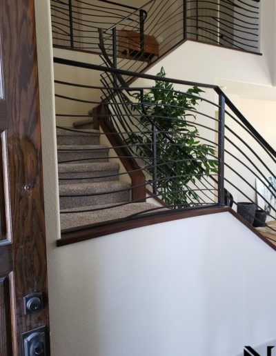 A staircase in a house with a metal railing