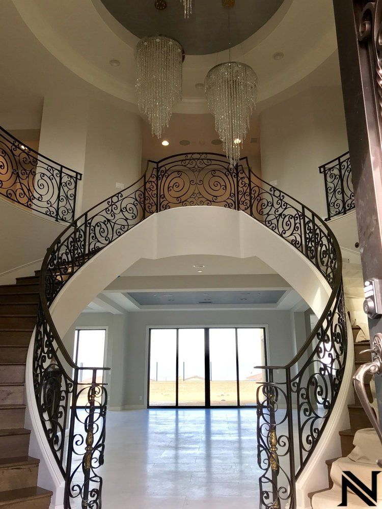 A large staircase in a house with a chandelier hanging from the ceiling.