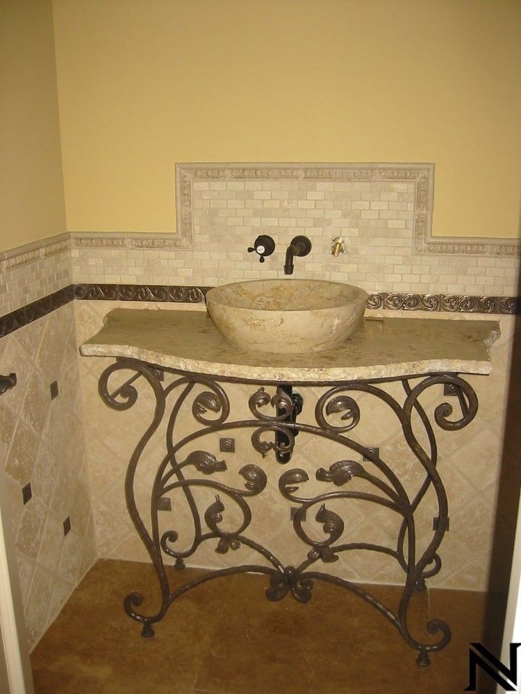 A bathroom with a wrought iron vanity and a sink