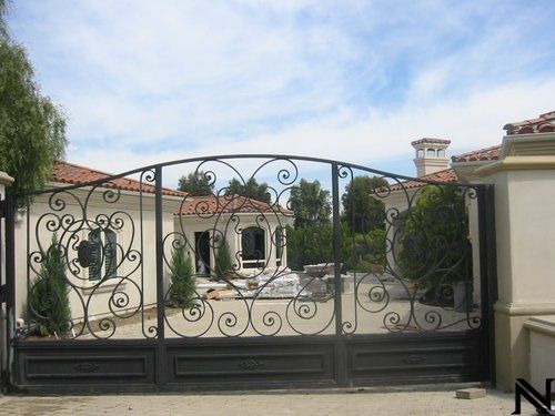 A large house with a wrought iron gate in front of it