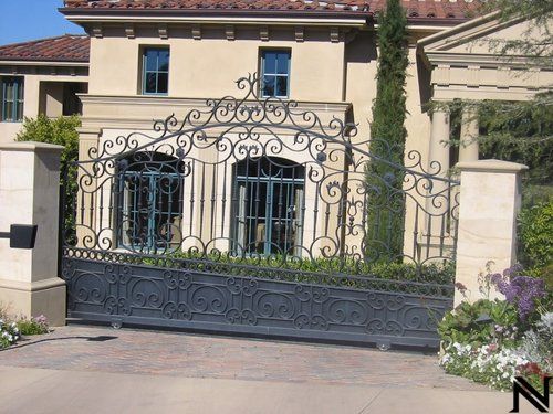 A large house with a wrought iron gate in front of it