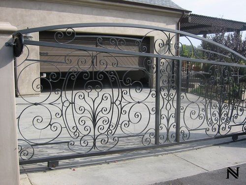 A wrought iron gate is in front of a garage.