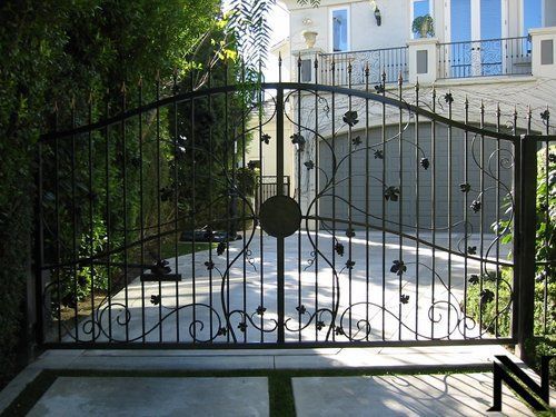 A wrought iron gate in front of a white house