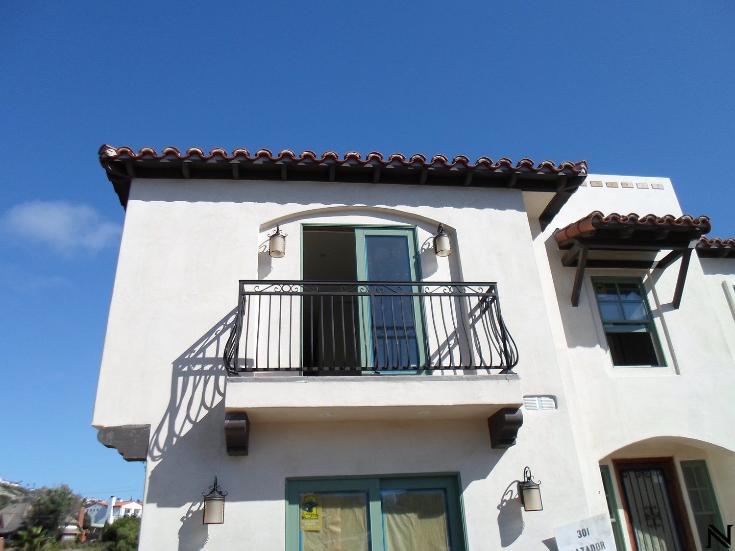 A white house with a balcony on the second floor