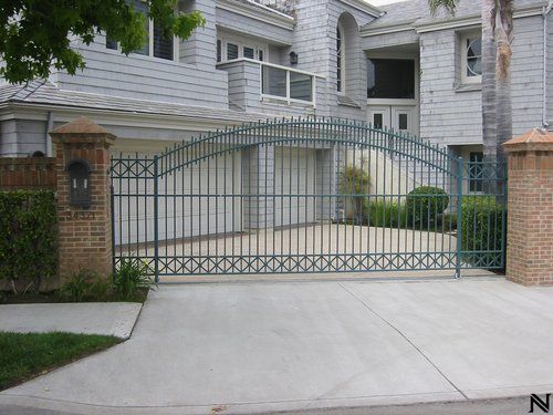 A large white house with a green gate in front of it