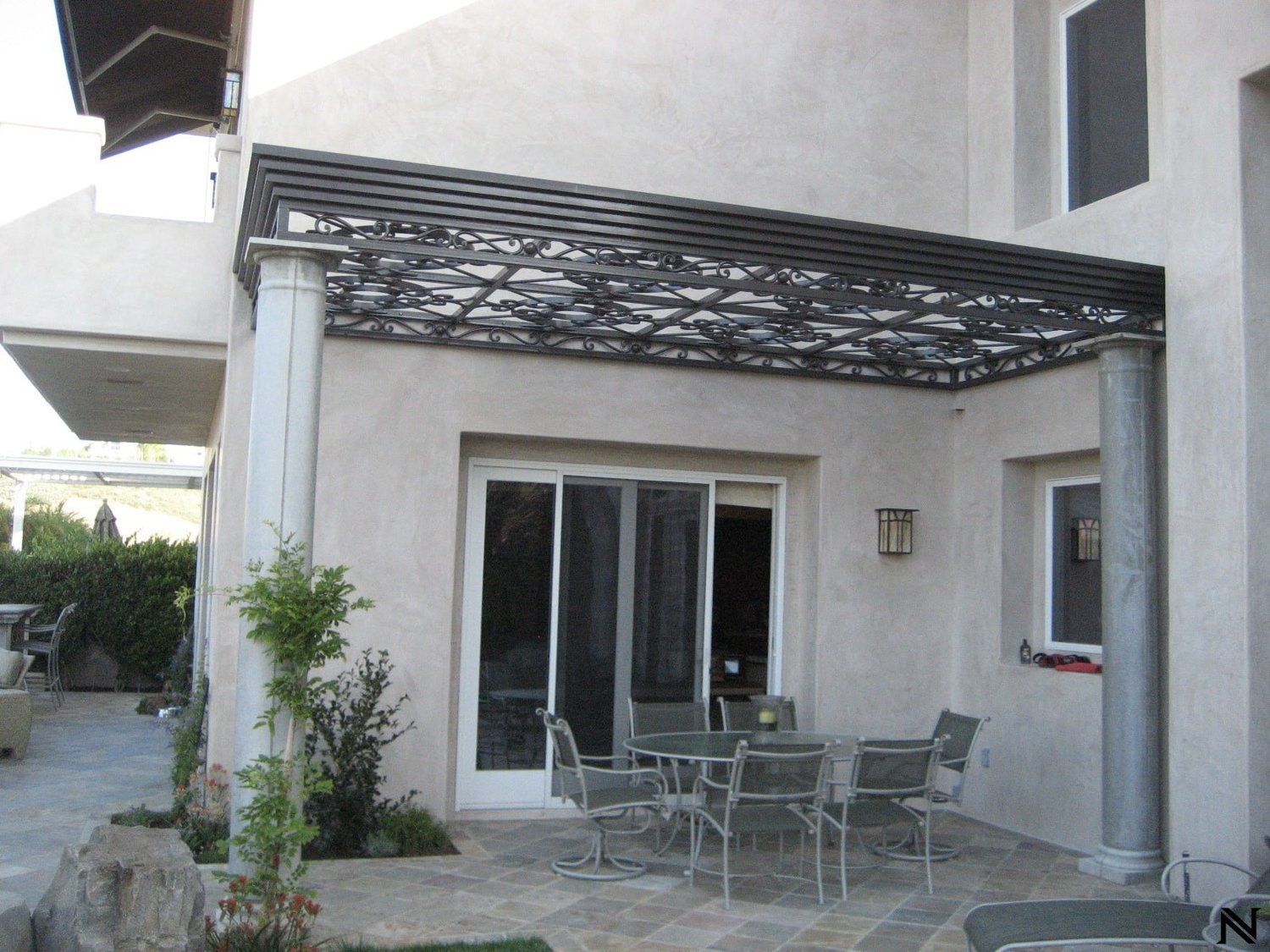 A patio with a table and chairs under a pergola