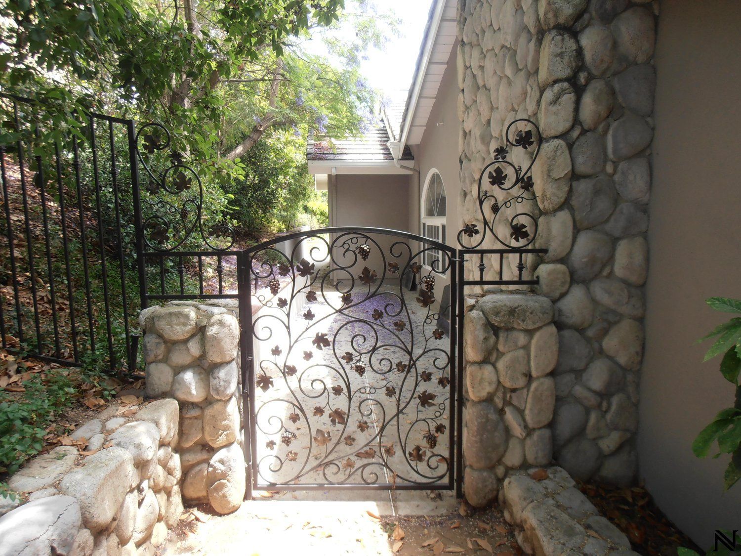 A stone wall with a wrought iron gate in front of it