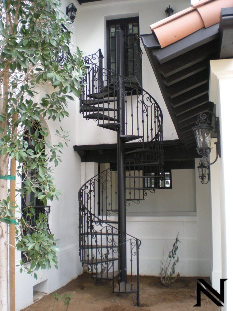 A wrought iron spiral staircase on the side of a building