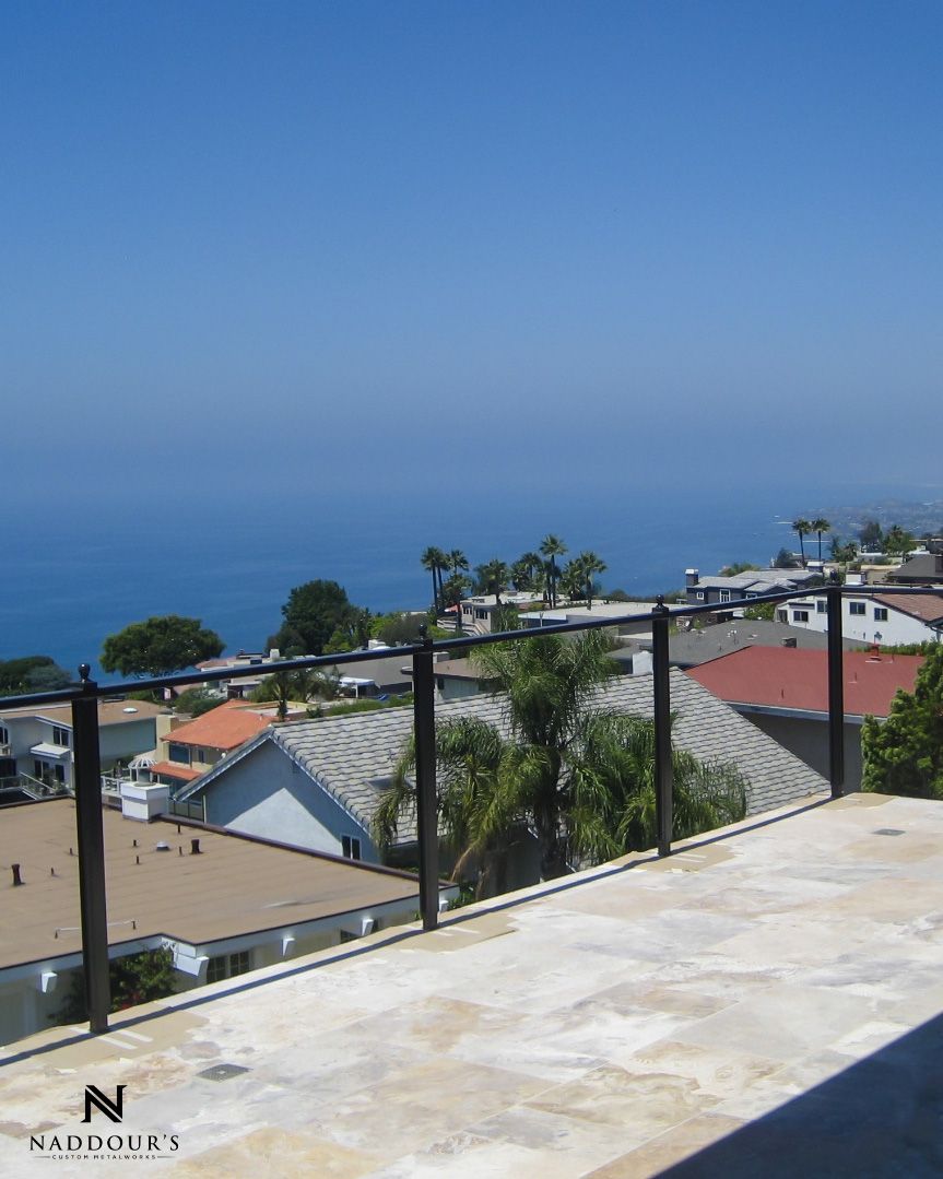 A balcony with a view of the ocean and houses