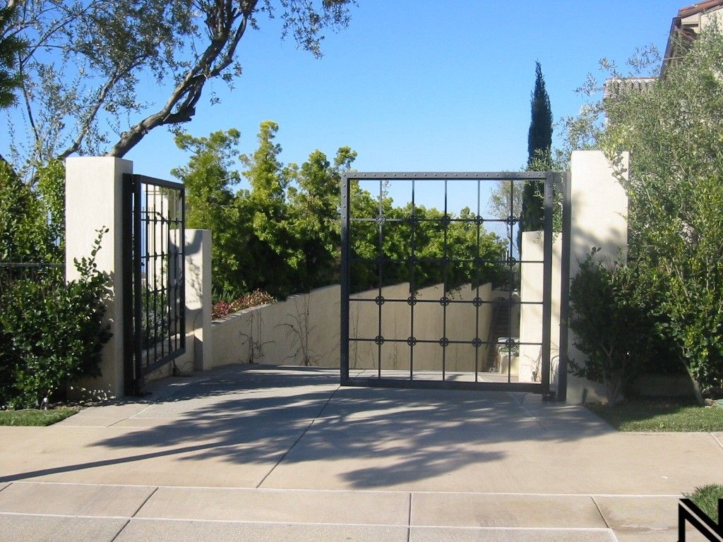 A concrete driveway with a gate that is open