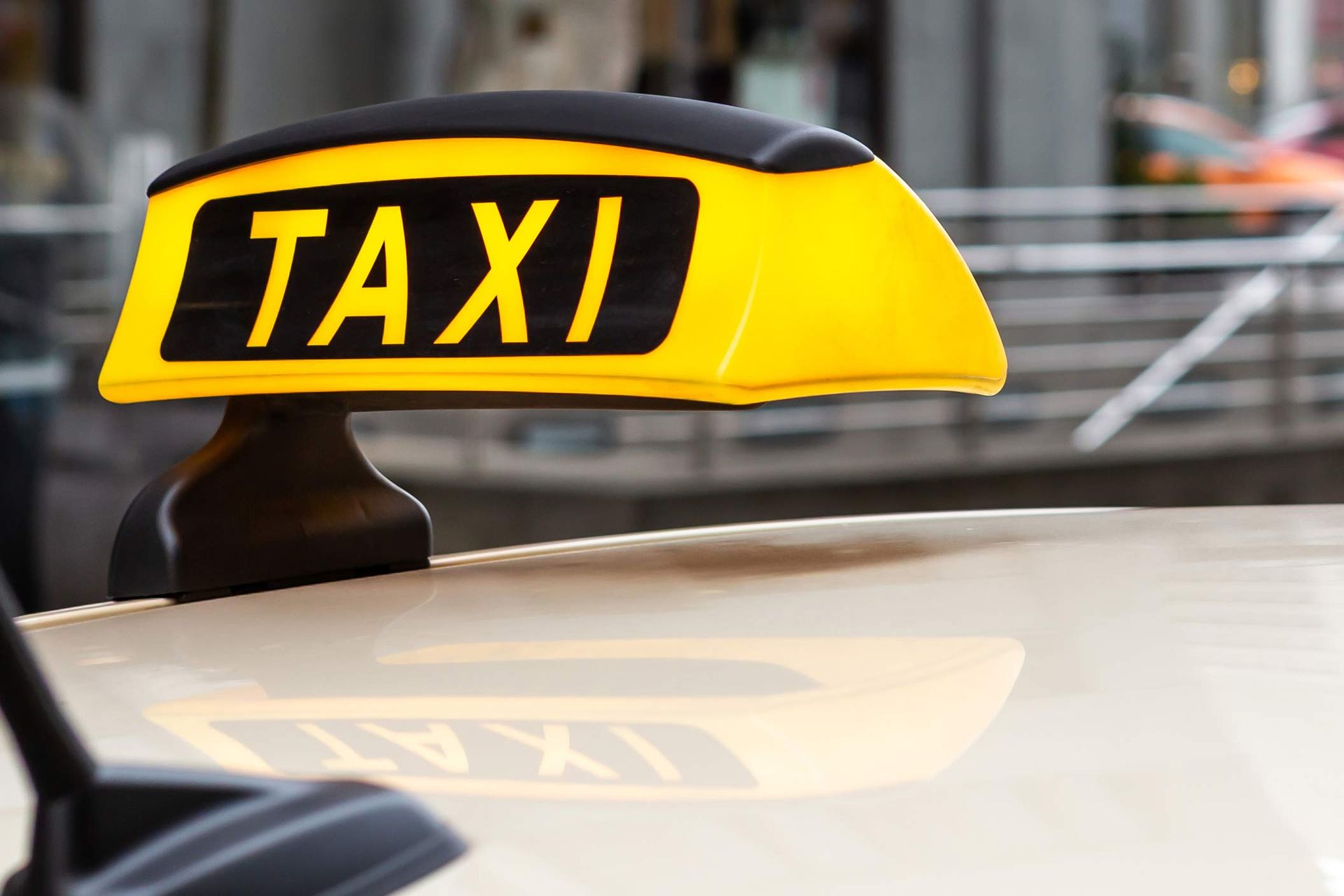 Taxi-sign on a car, highlighting taxi services.