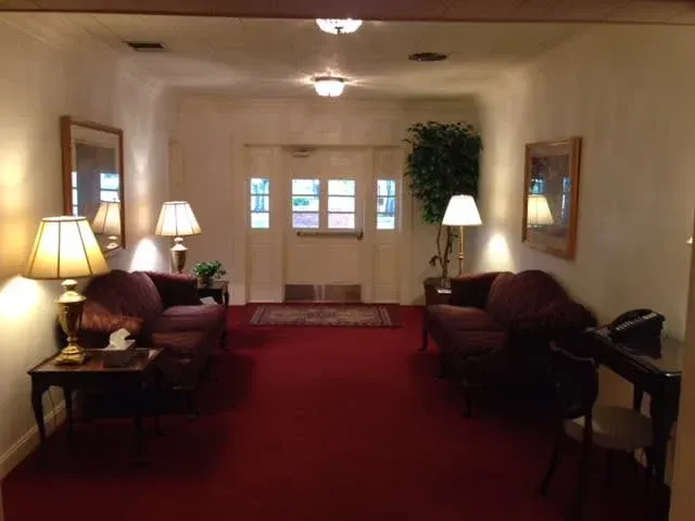 a living room with a blue sectional couch , chairs , and a coffee table .