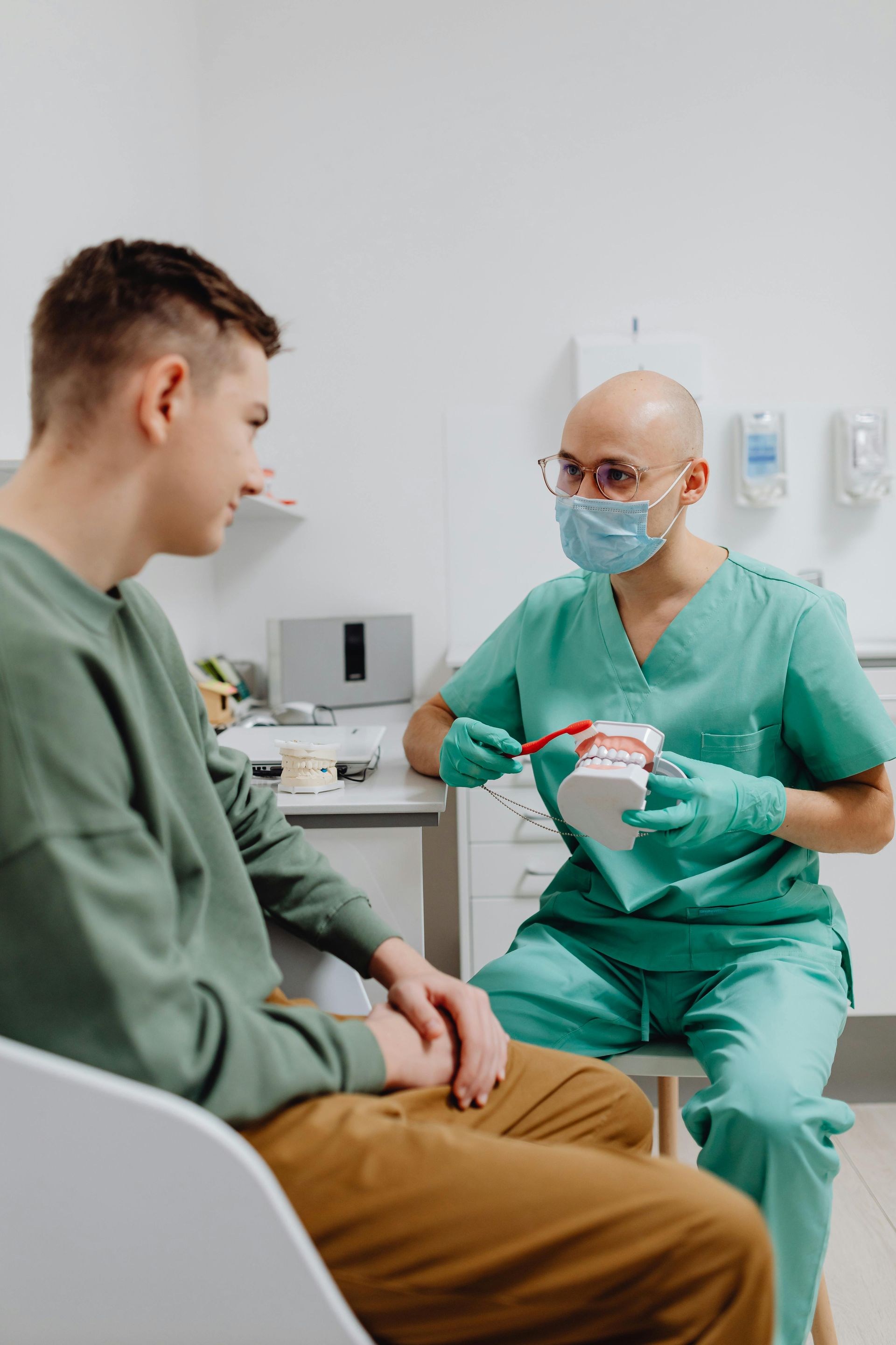A dentist is talking to a patient in a dental office.