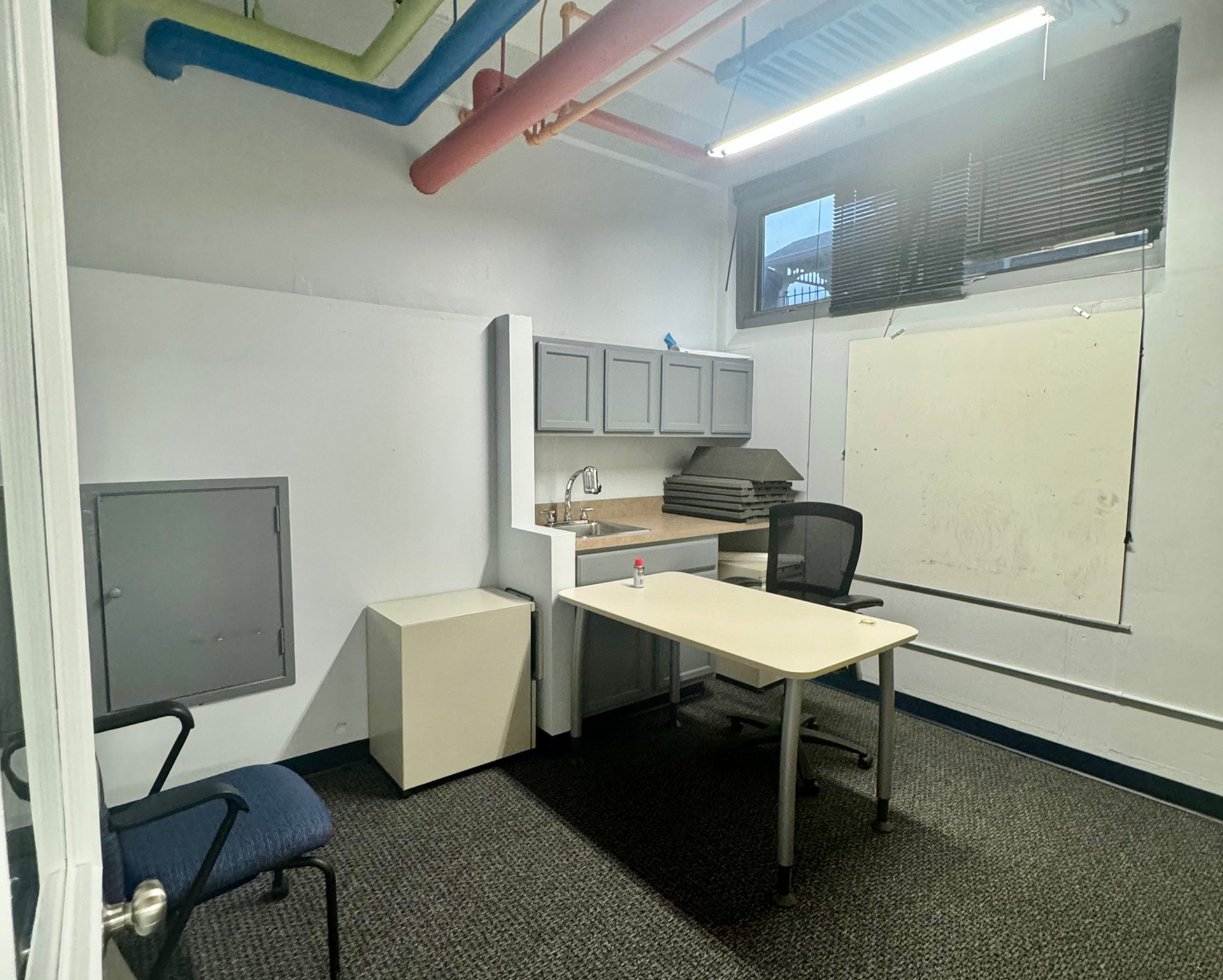 Two men are sitting at a long wooden table in a conference room