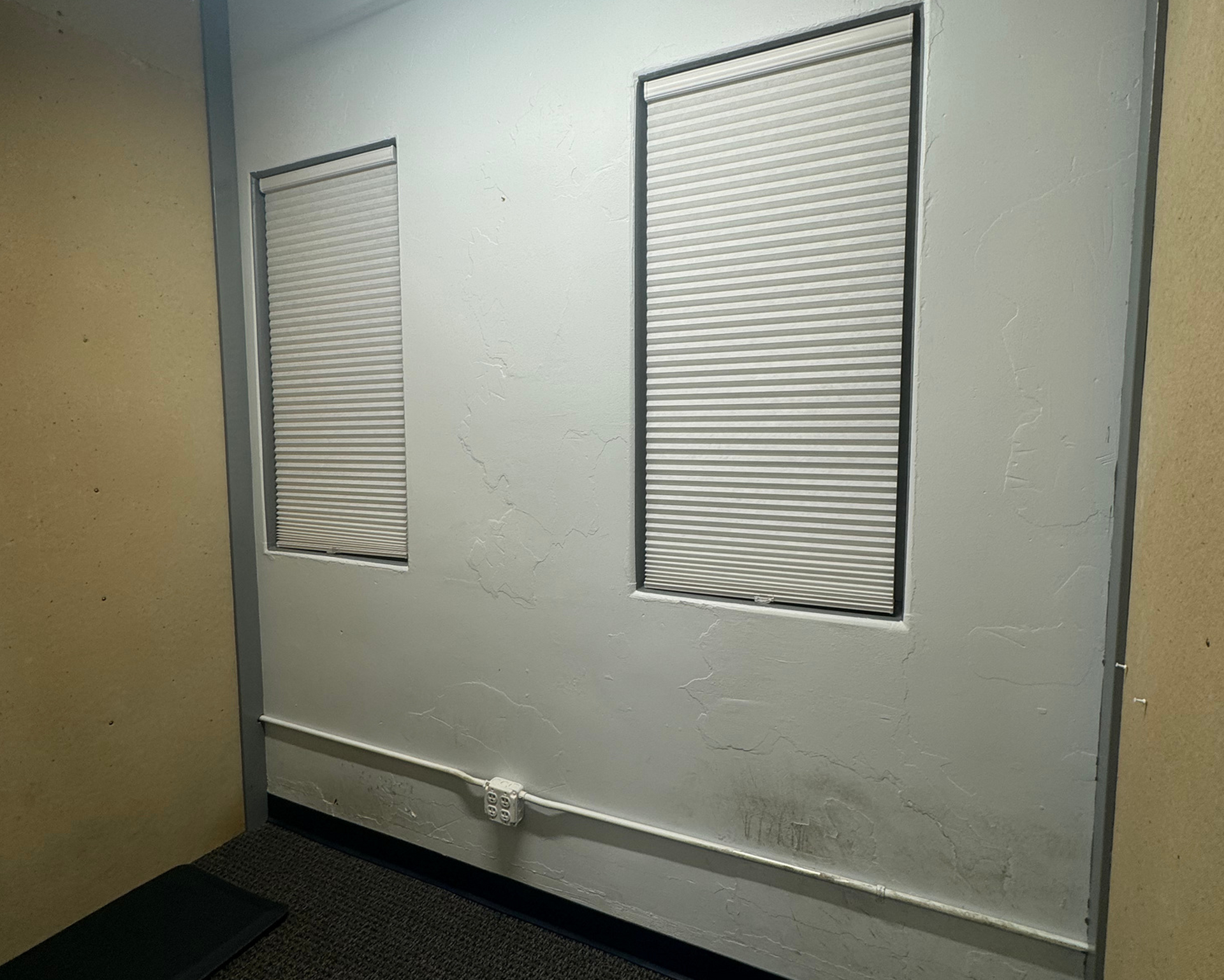 A man is sitting at a desk in front of a window