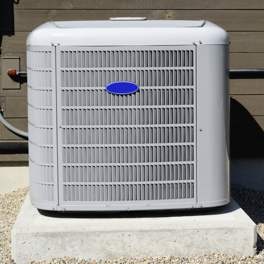 A carrier air conditioner is sitting on a concrete base