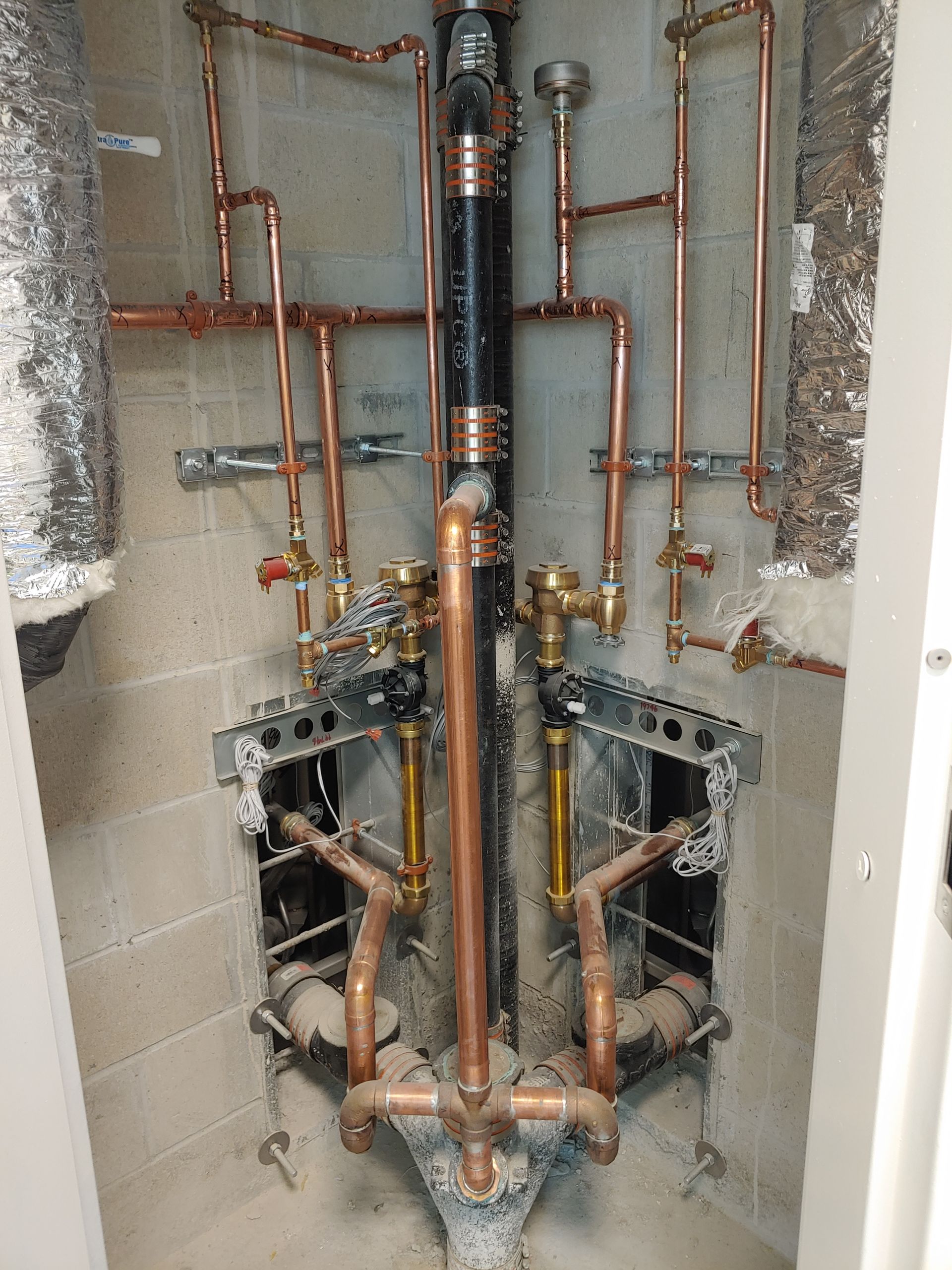 A room with a lot of copper pipes coming out of it.