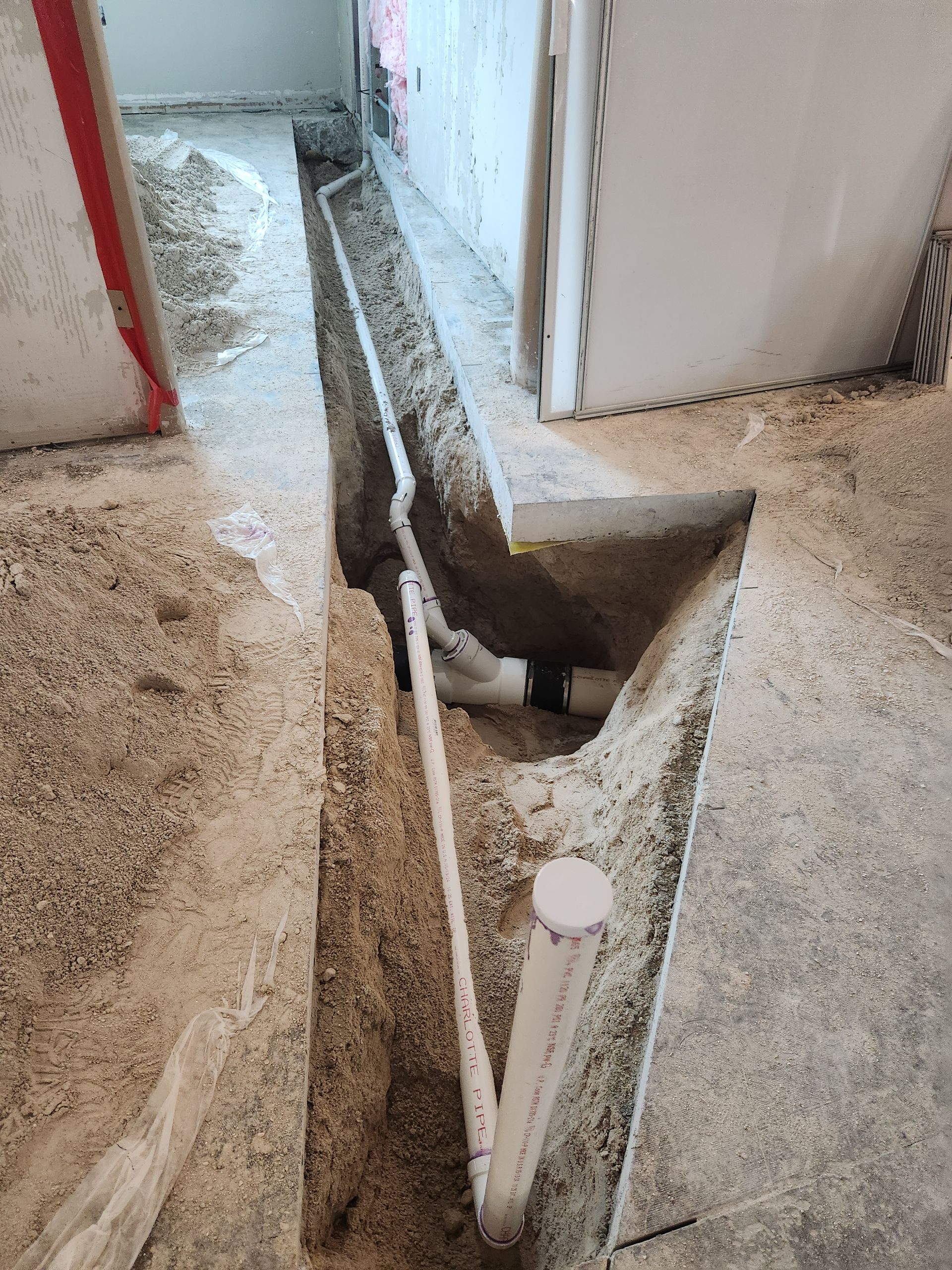 A pipe is being installed in a hole in the floor.