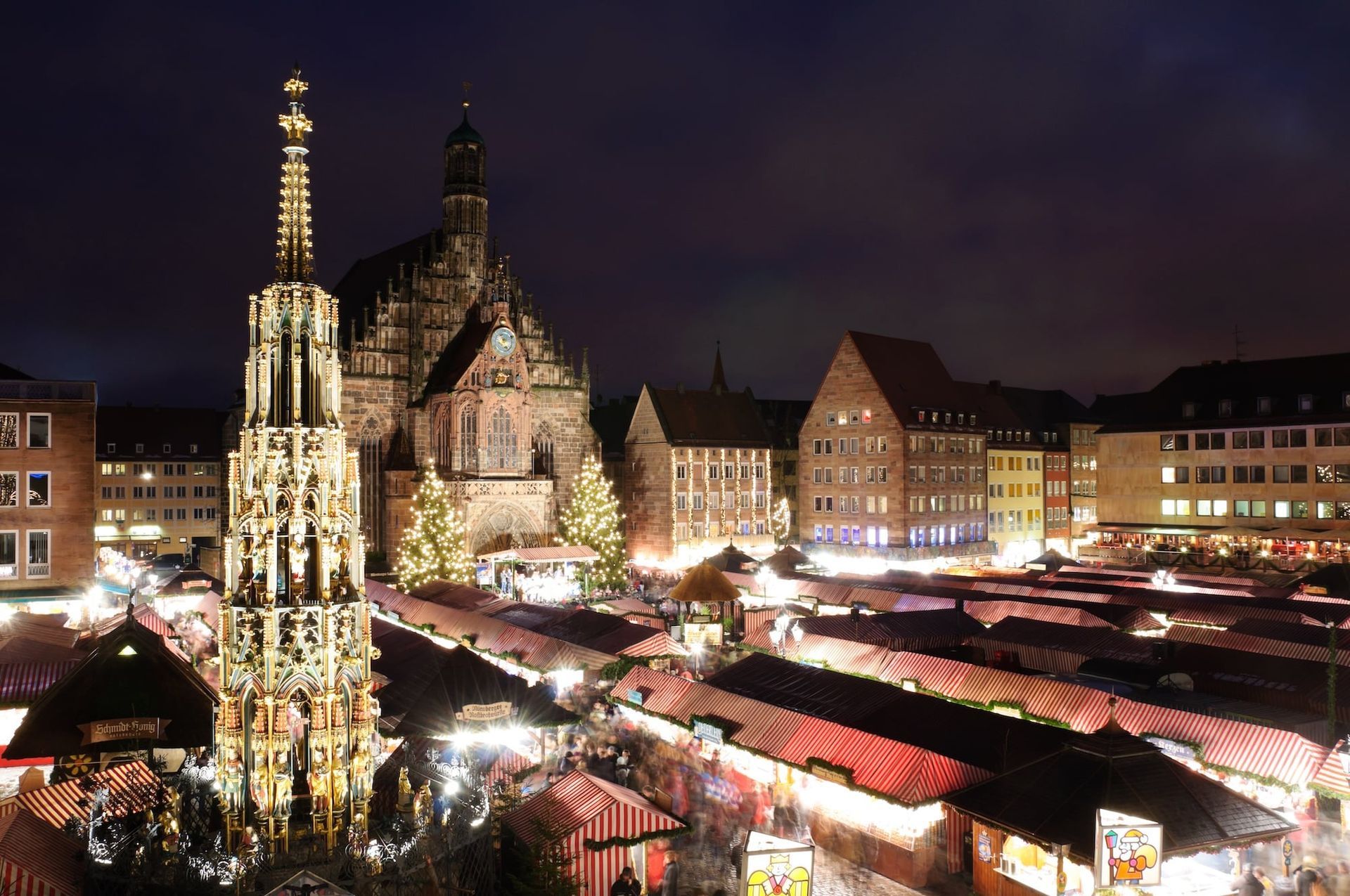 An aerial view of a nuremberg christmas market with a church in the background