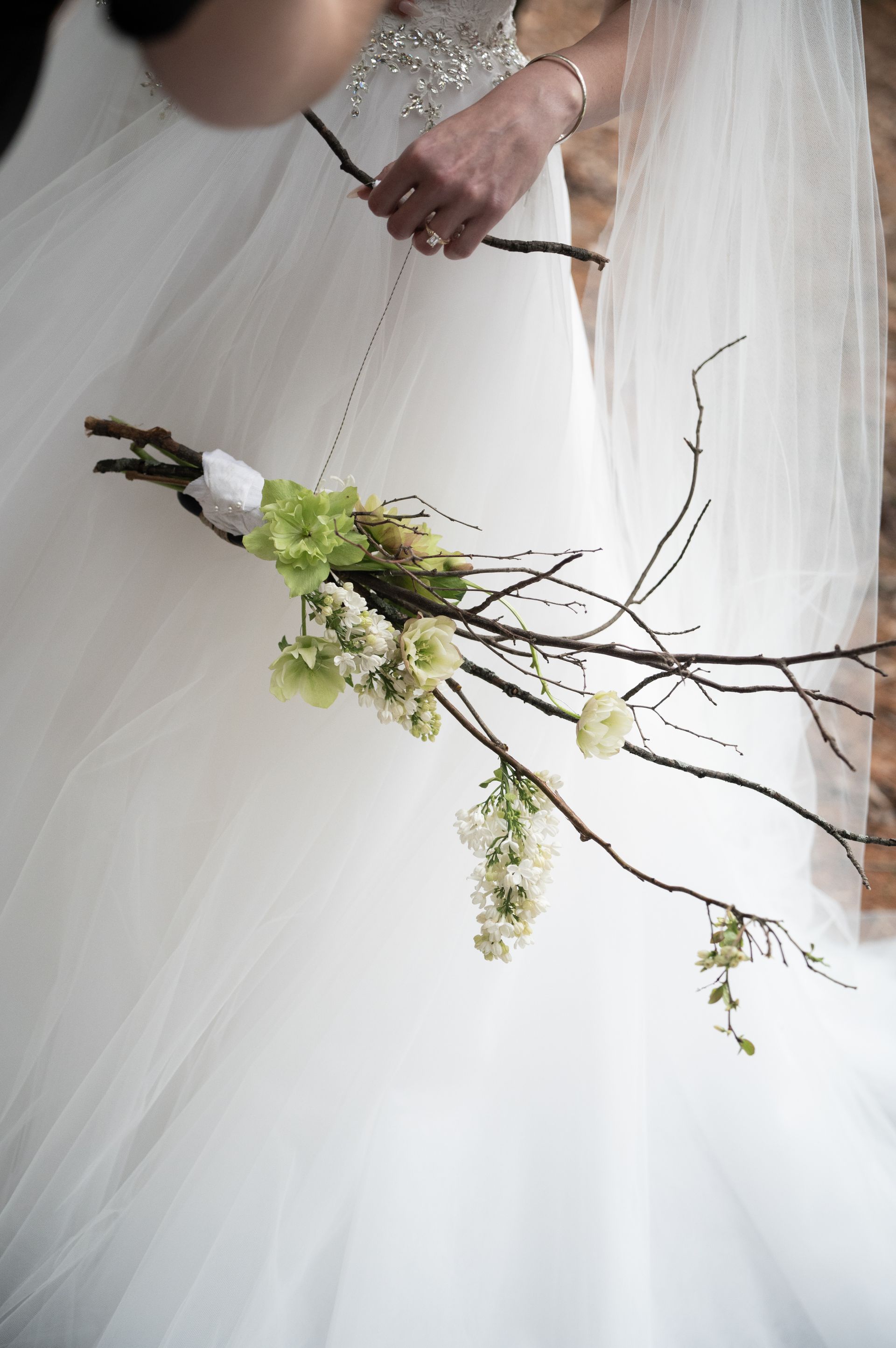 A bride in a white dress is holding a bouquet of flowers.