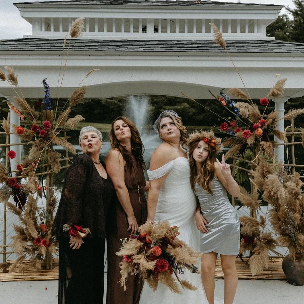 A bride and her bridesmaids are posing for a picture in front of a gazebo.
