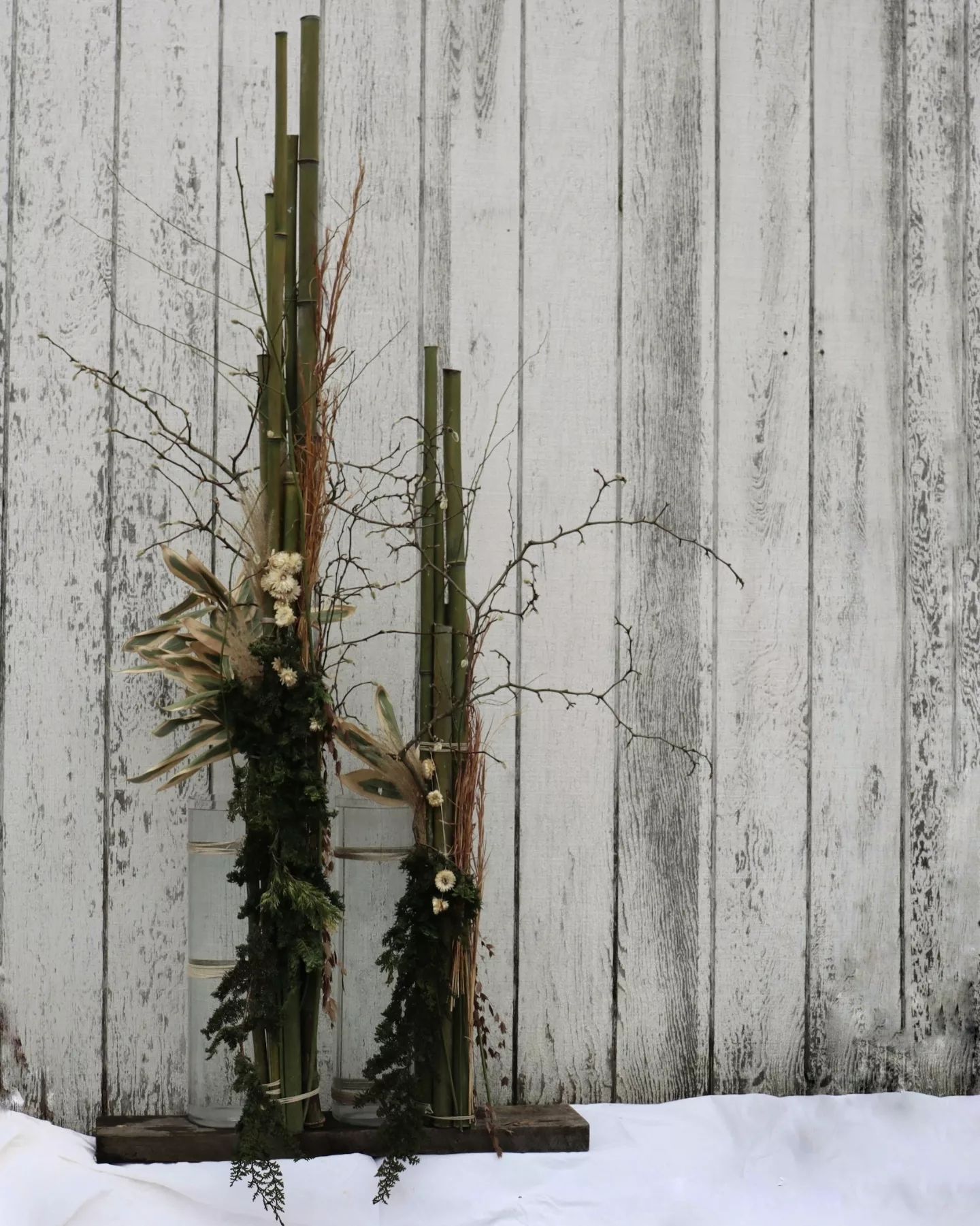 A wooden fence with a bunch of branches and flowers on it