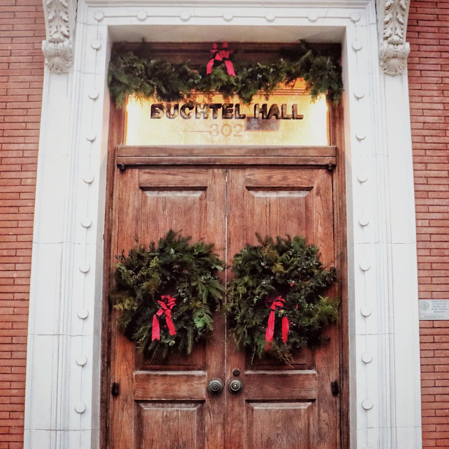 A wooden door with a sign above it that says fugitel hall
