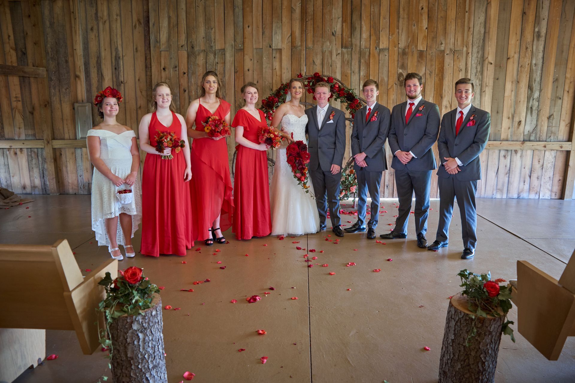 The bride and groom are posing for a picture with their wedding party.