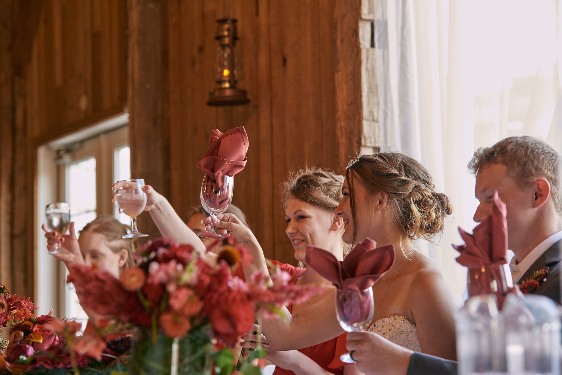 A group of people are toasting with wine glasses at a wedding reception.