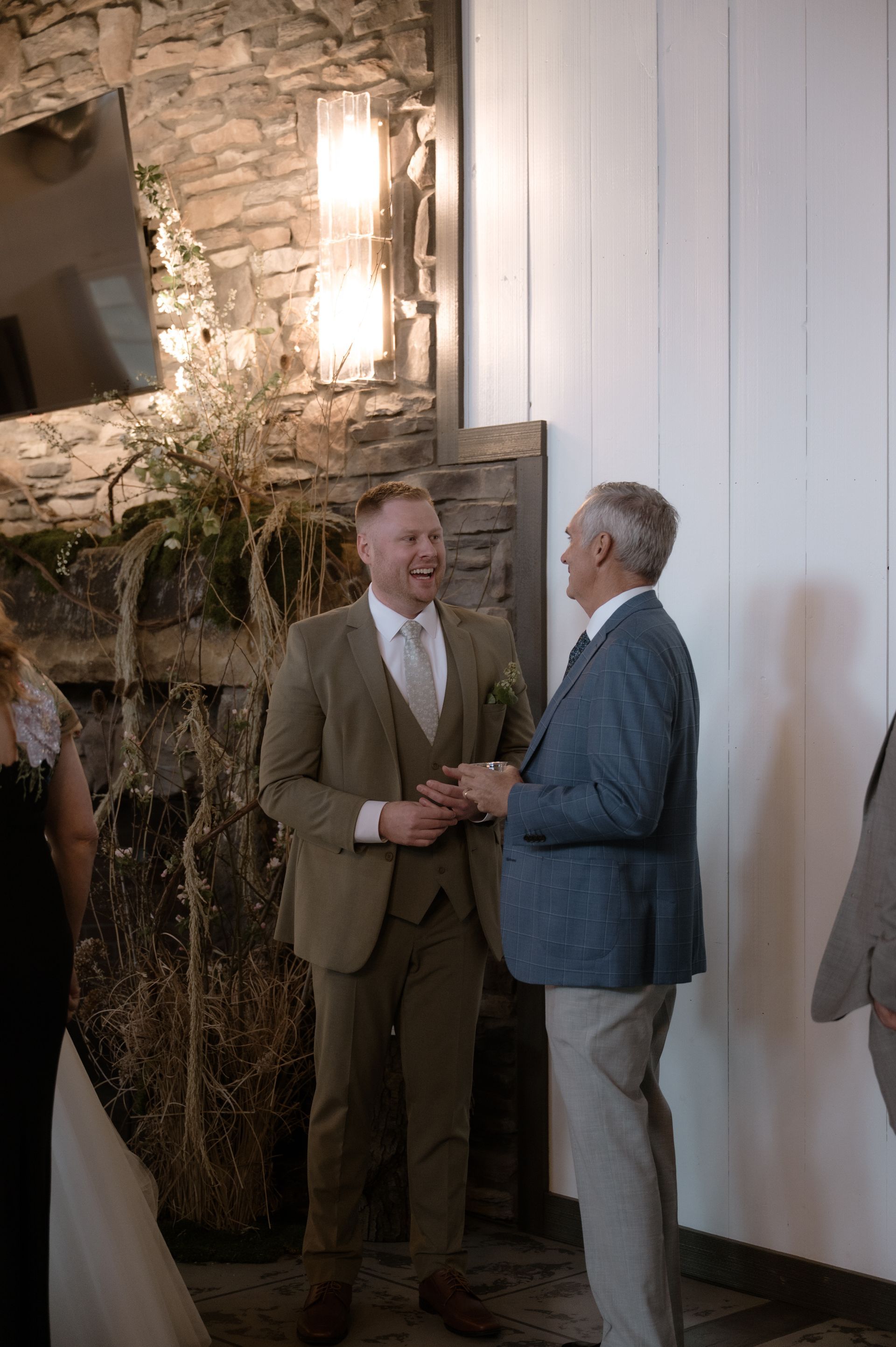 A bride and groom are standing next to each other in a room talking to each other.